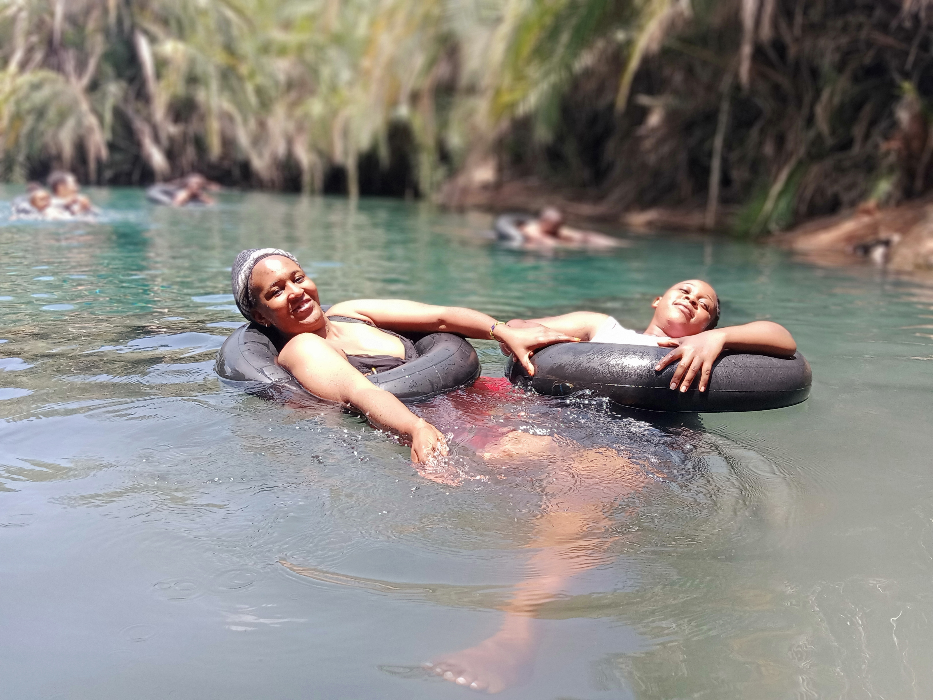 Tourists swimming and relaxing in the crystal clear geothermal waters of Chemka Kikuletwa Hot Springs near Moshi